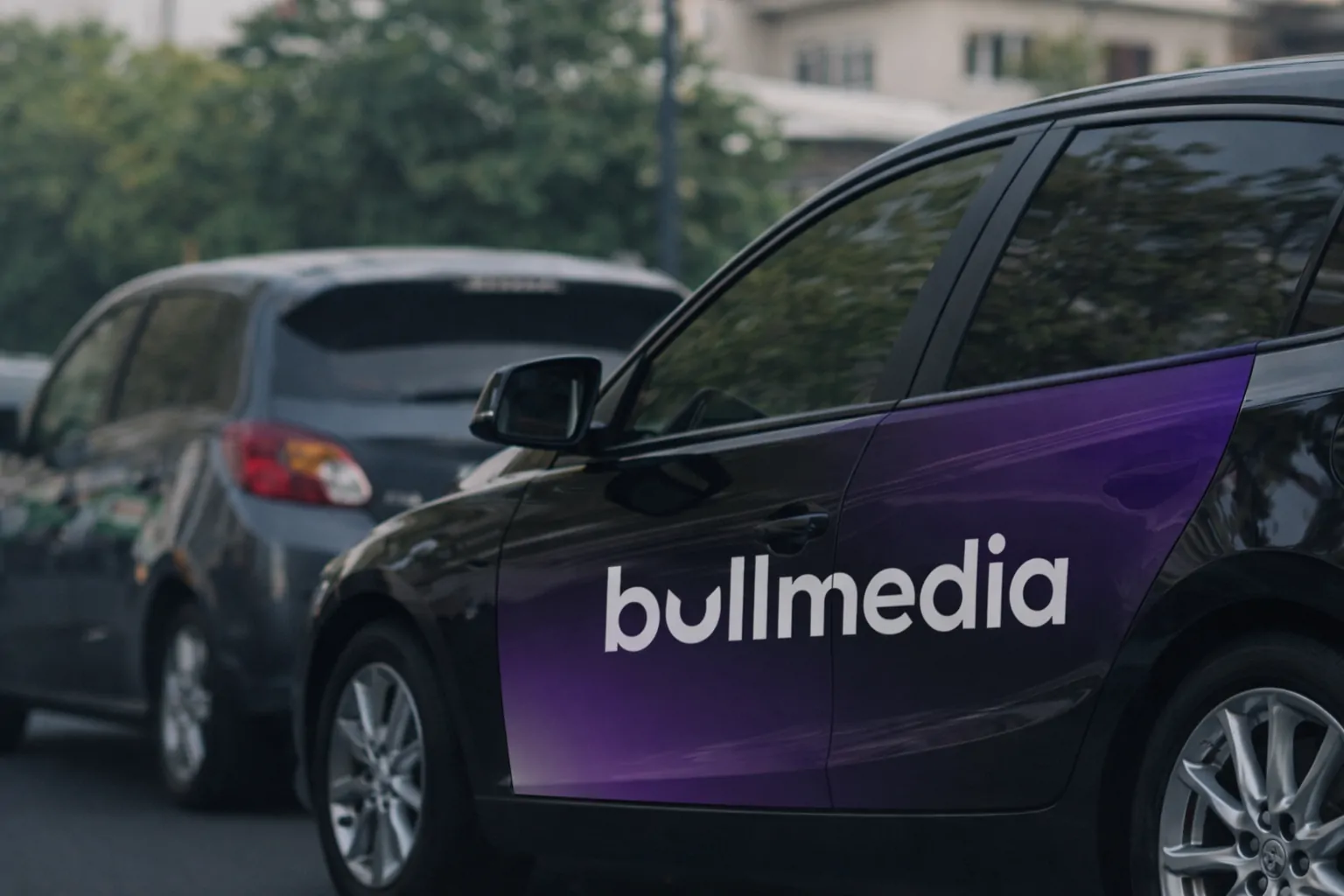 Auto con wrap de bullmedia en la calle